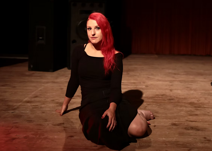 alithéa assise au centre de la photo avec des vêtements noirs